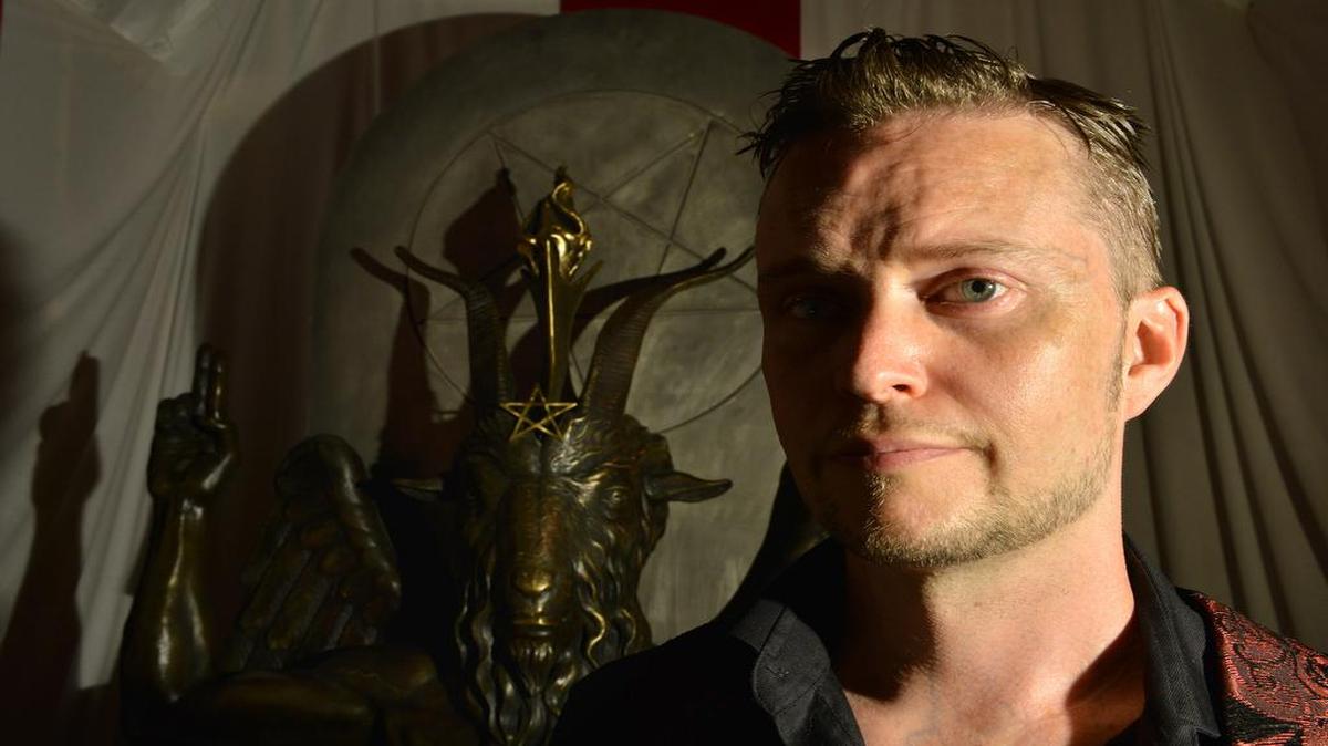 Doug Mesner, who also goes by the name Lucien Greaves, a spokesman for the Satanic Temple, with a statue of Baphomet at the group's meeting house in Salem, Mass.