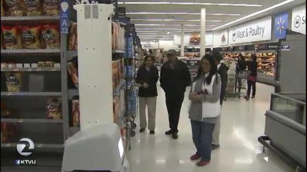 Customers at a Walmart in Milpitas, Calif., check out a robot that scans shelves for out-of-stock or mislabeled products in a KTVU report. Walmart is testing the robots at 50 stores, including three in the Bay Area of California.