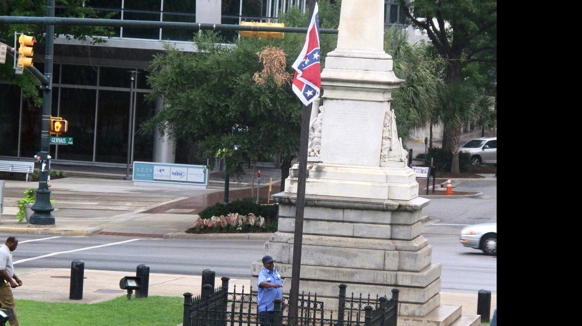
Workers raise the flag at a Confederate monument in front of the Statehouse in Columbia, S.C., on Saturday, June, 27, 2015. The flag had been removed about 45 minutes earlier by an activist. 
