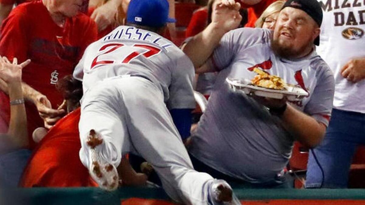Chicago Cubs shortstop Addison Russell dives into the crowd but is unable to catch a foul ball hit by St. Louis Cardinals' Jedd Gyorko during the second inning of a baseball game Monday, Sept. 25, 2017, in St. Louis.