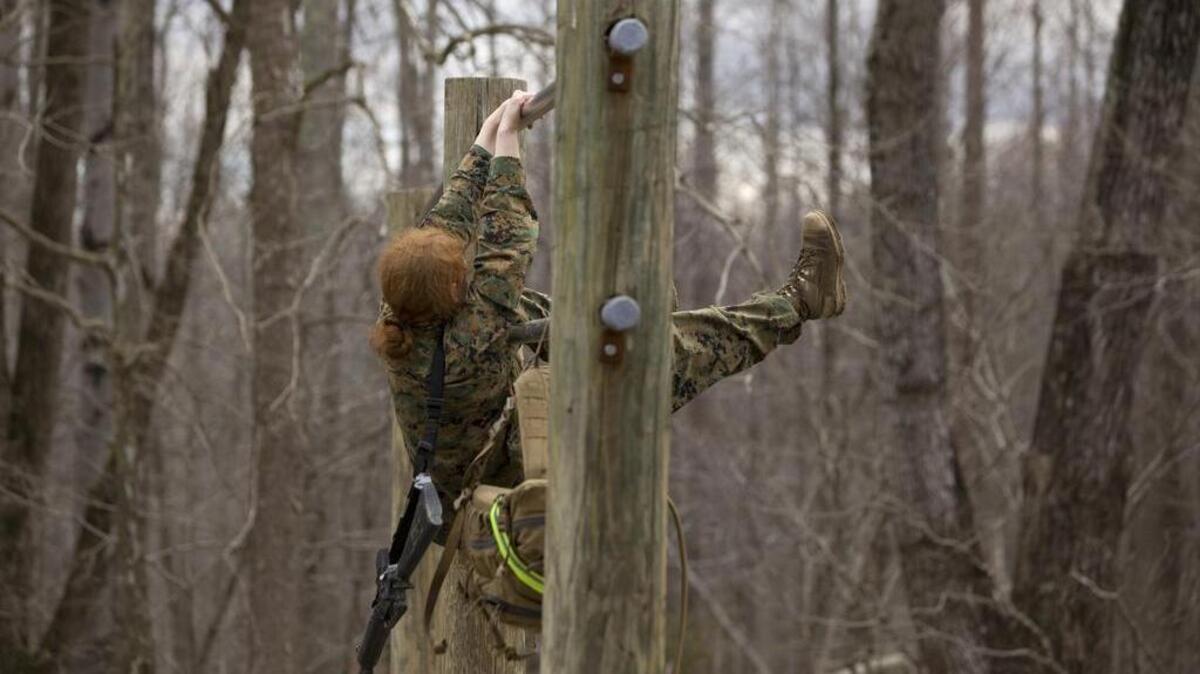 A woman works her way through the obstacles in the Infantry Officer Course at the Marine Corps Base in Quantico, Va., in 2013. A congresswoman from Maine says the U.S. Marine Corps should change tattoo rules she says unintentionally discriminate against female recruits.