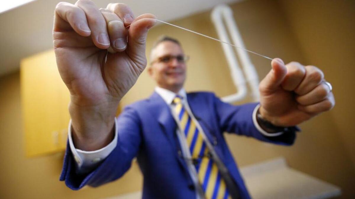 Dr. Wayne Aldredge, president of the American Academy of Periodontology, holds a piece of dental floss at his office in Holmdel, N.J. Aldredge acknowledges the weak scientific evidence and the brief duration of many studies on flossing, but says that the impact of floss might be clearer if researchers focused on patients at the highest risk of gum disease, such as diabetics and smokers.