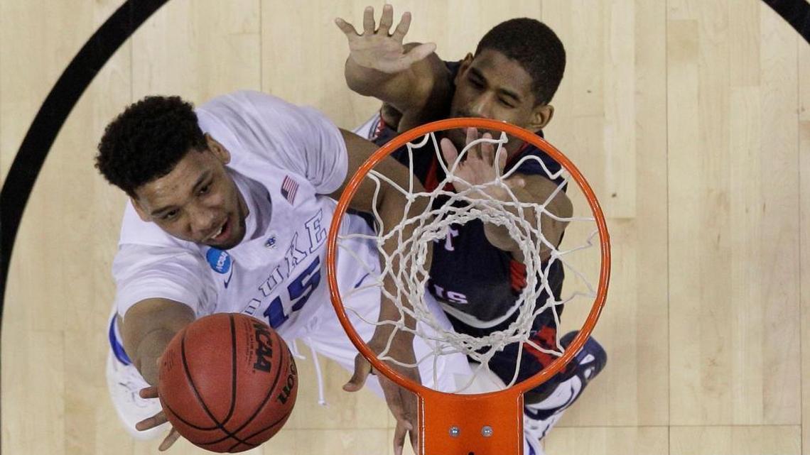 FILE - In this March 20, 2015 file photo, Duke's Jahlil Okafor, left, shoots over Robert Morris' Rodney Pryor, right, during the second half of an NCAA tournament college basketball game in Charlotte, N.C. Both the NCAA and the ACC this week announced it will not hold upcoming collegiate tournament games in North Carolina due to a state law some say can lead to discrimination against LGBT people. Now, other states and some cities are clamoring to hold those displaced games.