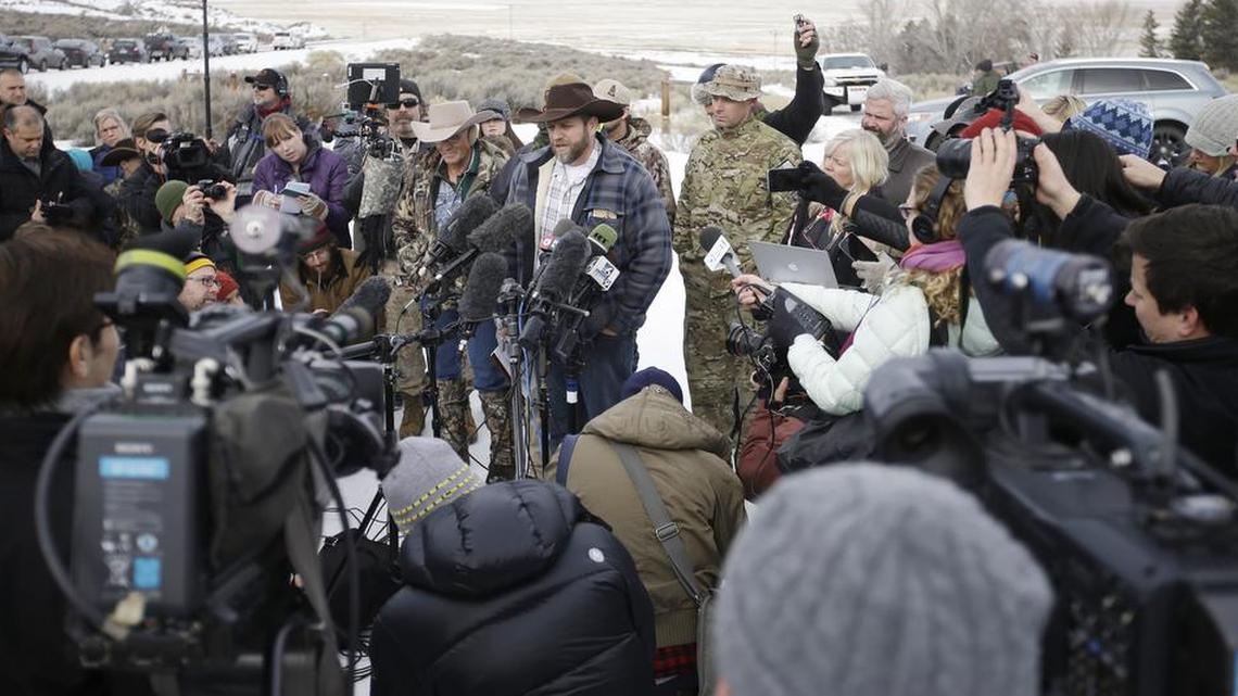 Ammon Bundy (center), one of the sons of Nevada rancher Cliven Bundy, speaks with reporters during a Monday news conference at Malheur National Wildlife Refuge headquarters near Burns, Ore. Bundy, who was involved in a 2014 standoff with the government over grazing rights, said two local ranchers who face long prison sentences for setting fire to land have been treated unfairly. The armed anti-government group took over the remote national wildlife refuge in Oregon as part of a decades-long fight over public lands in the West.