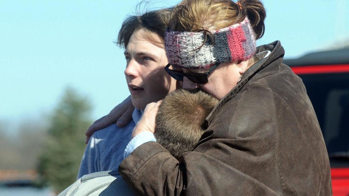 A child is comforted Monday near Middletown, Ohio, after a school shooting at Madison Local Schools. An Ohio sheriff says a 14-year-old suspect in a school shooting that wounded four classmates, including two who were shot, is in a juvenile lock-up and facing several charges. Butler County Sheriff Richard Jones says the boy has been charged with two counts of attempted murder, two counts of felonious assault, inducing panic and making terrorist threats.