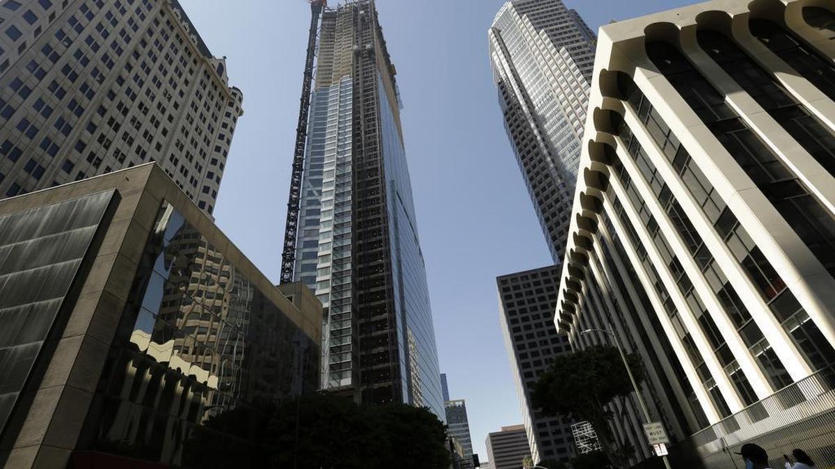 Passersby look up at the Wilshire Grand Tower on South Figueroa Street where a worker fell to his death on Thursday. A fire department spokesperson said the the construction worker plunged 50 stories to his death from the building under construction and hit the back of a passing car in downtown Los Angeles.