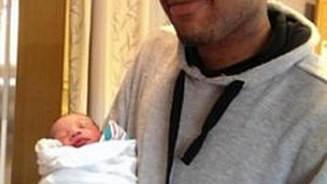 
John Crawford III holds a baby in this undated photo. He was the father of two children.
