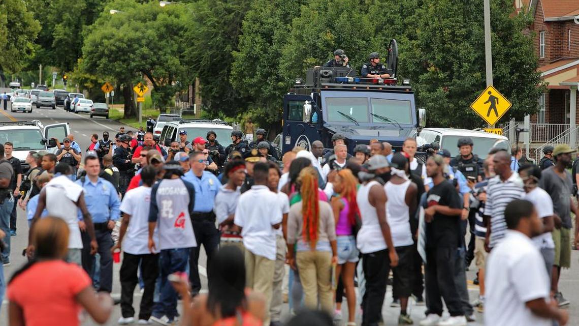 
People gather at the scene of a fatal officer-involved shooting Wednesday in St. Louis. An armed man fleeing from officers serving a search warrant at a home in a crime-troubled section of north St. Louis was shot and killed Wednesday by police after he pointed a gun at them, the police chief said.
