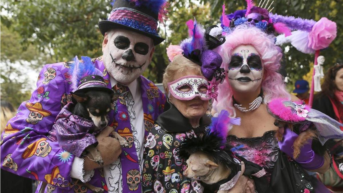 Danny Cox, left, with his Chihuahua Paco, Alice Woodroof, center, with her Chihuahua Pearl and Amy Cox with her Yorkshire Terrier Penelope, all from Dallas, Texas, wear Day of the Dead costumes in the annual Tompkins Square Halloween Dog Parade in New York on Saturday. Hundreds of dogs took part in what's billed as the nation's largest Halloween dog parade.