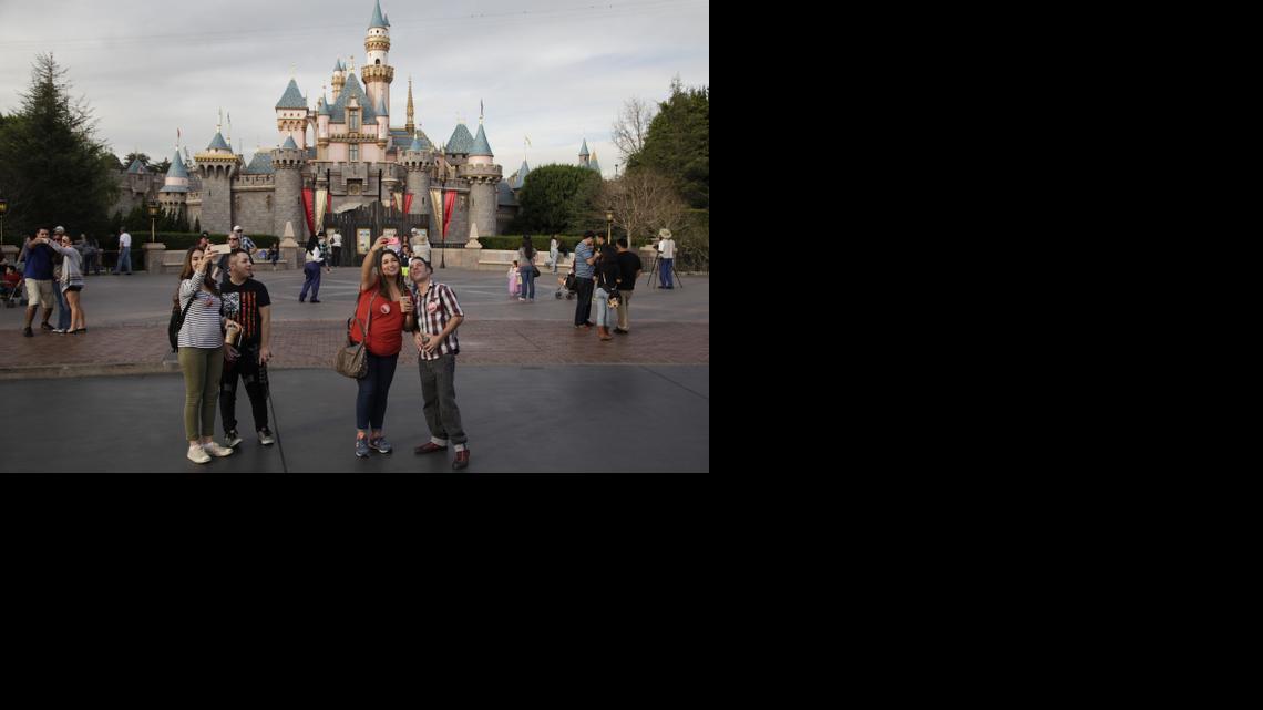 
People take pictures in front of the Sleeping Beauty’s Castle at Disneyland, Thursday, Jan. 22, 2015, in Anaheim, Calif. Several people have been infected in a measles outbreak that led California public health officials to urge those who haven’t been vaccinated against the disease, including children too young to be immunized, to avoid Disney parks where the spread originated. 
