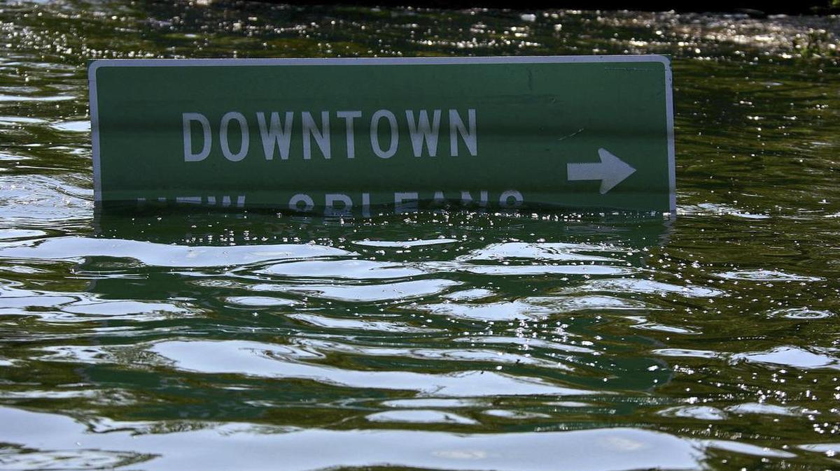 A road sign, nearly submerged under floodwaters during following hurricane Katrina, in New Orleans, Aug. 31, 2005. The storm struck the Gulf Coast with devastating force at daybreak on Aug. 29, 2005, pummeling a region that included the fabled city of New Orleans and heaping damage on neighboring Mississippi. In all, more than 1,700 people were killed and hundreds of thousands of others displaced.
