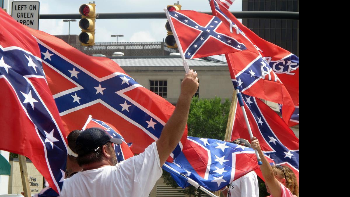 
Supporters of keeping the Confederate battle flag flying at a Confederate monument at the South Carolina Statehouse wave flags during a rally in front of the statehouse in Columbia, S.C., on Saturday, June 27, 2015. Gov. Nikki Haley and a number of other state leaders have called for the removal of the flag following the shooting deaths of nine black parishioners in a church in Charleston last week.

