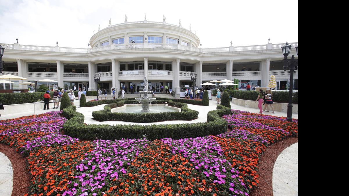 
In this March 7, 2015, photo, people walk near the Trump National Doral Miami clubhouse during a golf tournament in Doral, Fla. NASCAR said July 3, 2015, it will not hold its season-ending awards ceremony at the Trump National Doral Miami. 
