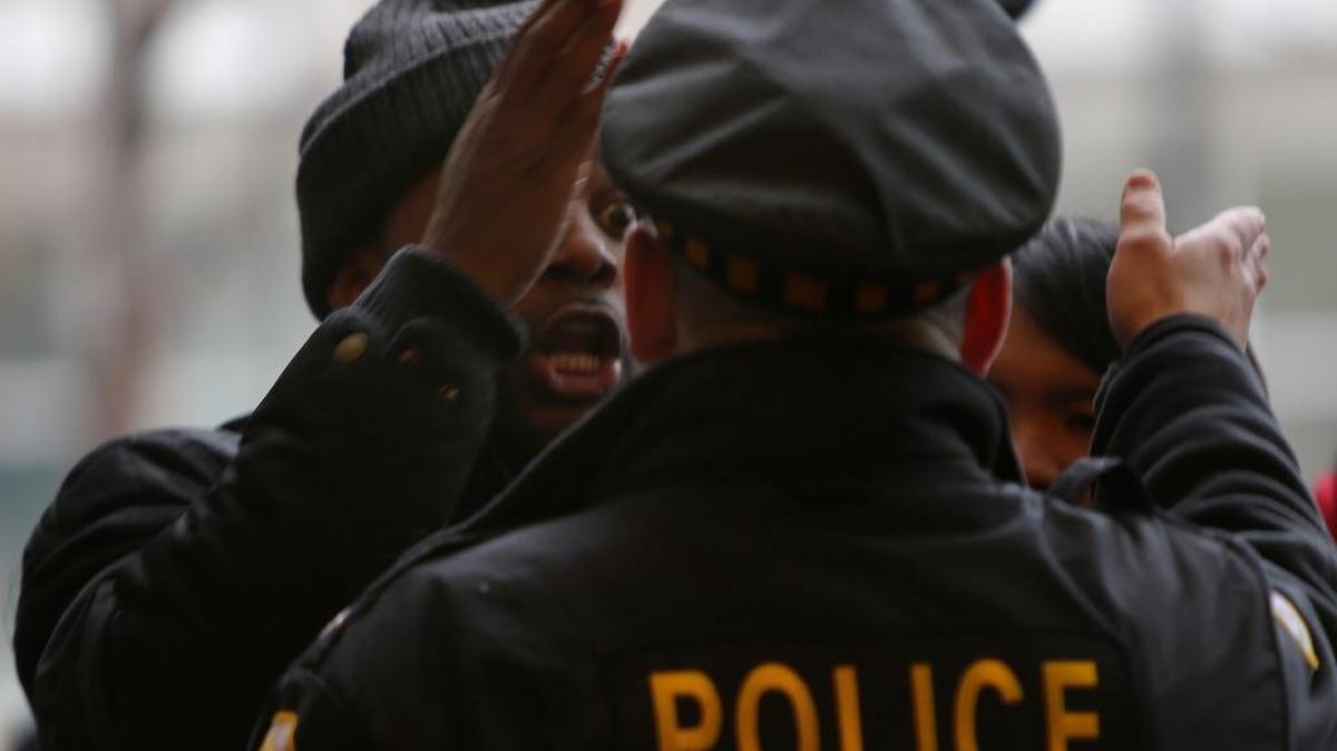 A protester argues with police outside the 30th Annual Interfaith Breakfast at the Hyatt Regency McCormick Place hotel on Jan. 15, 2016, in Chicago.
