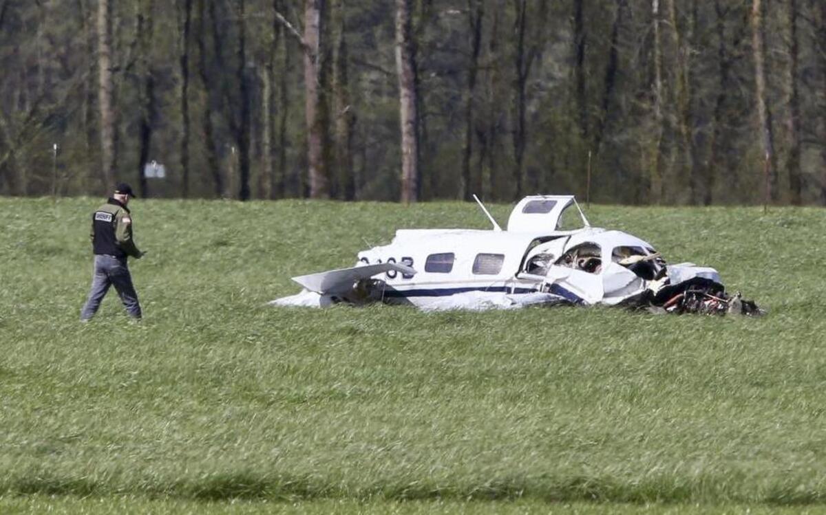A Linn County Sheriff’s deputy approaches the scene of a small plane crash north of Harrisburg, Ore., that left four people dead, Friday April 7, 2017.