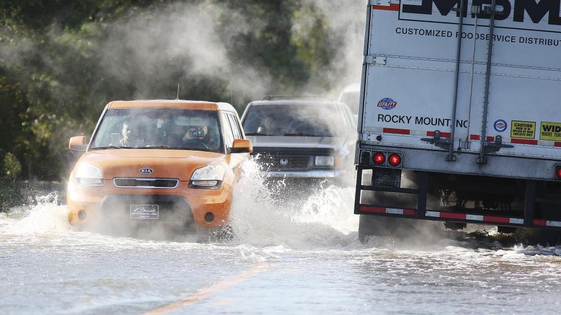 Shannon Stone takes a video with her phone as she drives through water running across the road just north of Bennetts Bridge on N.C. 111 South in Goldsboro, N.C., Tuesday, Oct.11, 2016.