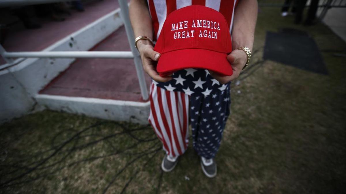 A man holds “Make America Great Again” hats before a Donald Trump rally at the Ladd–Peebles Stadium, Saturday, Dec. 17, 2016, in Mobile, Ala. A Georgia school district has apologized after a teacher asked two high school students wearing “Make America Great Again” T-shirts to leave her classroom.