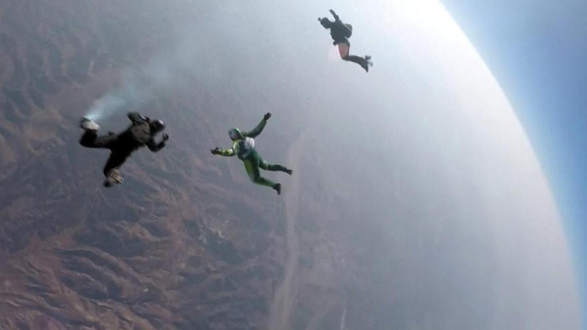 In this image made from a video provided by Mondelez International, Luke Aikins, center, skydives without a parachute over Simi Valley, Calif., Saturday, July 30, 2016. After a two-minute freefall, Aikins landed in a 100-by-100-foot net at the Big Sky movie ranch.