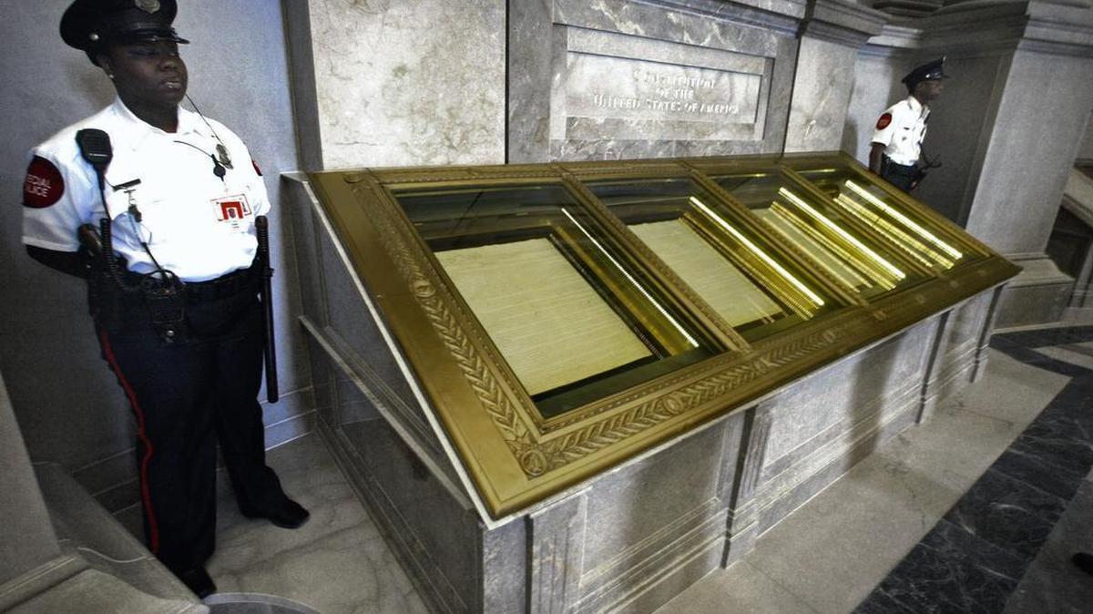Guards stand next to the U.S. Constitution in the rotunda of the National Archives in Washington.