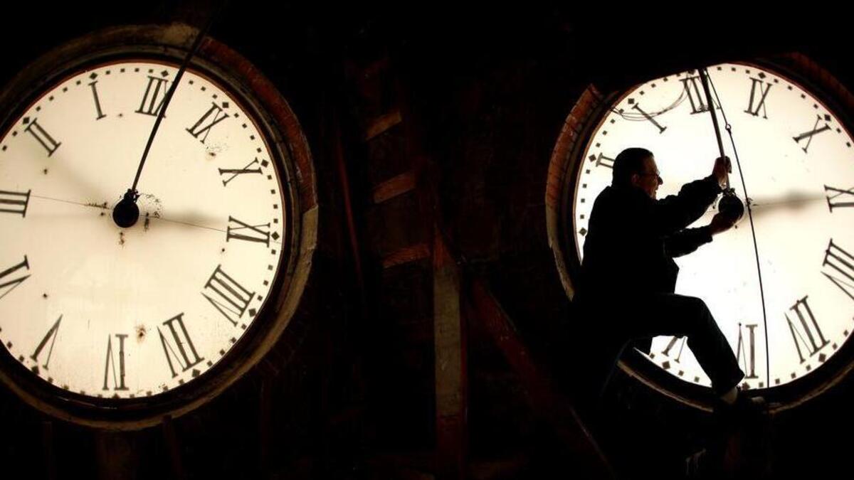 Custodian Ray Keen inspects a clock face before changing the time on the 100-year-old clock atop the Clay County Courthouse in Clay Center, Kan. Americans get a second extra on New Year’s Eve this year.