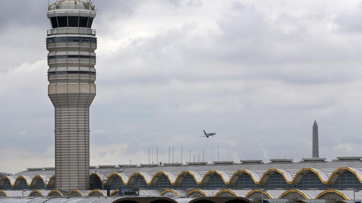 
An airplane flies between the air traffic control tower and the Washington Monument at Washington’s Ronald Reagan National Airport, Monday, Aug. 10, 2015. For more than three years, the government has kept secret a study it requested that found air traffic controllers’ work schedules often lead to chronic fatigue, making them less alert and endangering the safety of the national air traffic system, according to report on the study obtained by The Associated Press.

