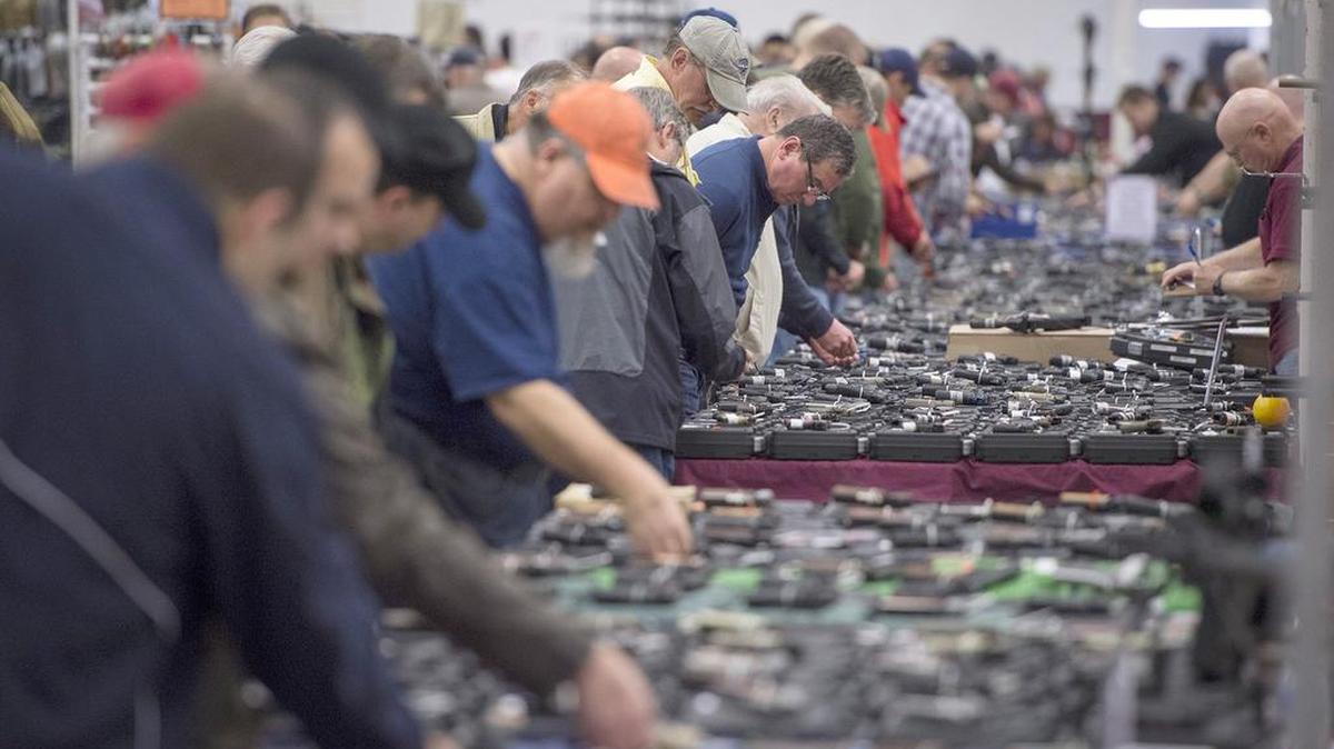 People look at handguns at a gun show Saturday, Oct. 3, 2015, in Chantilly, Va.