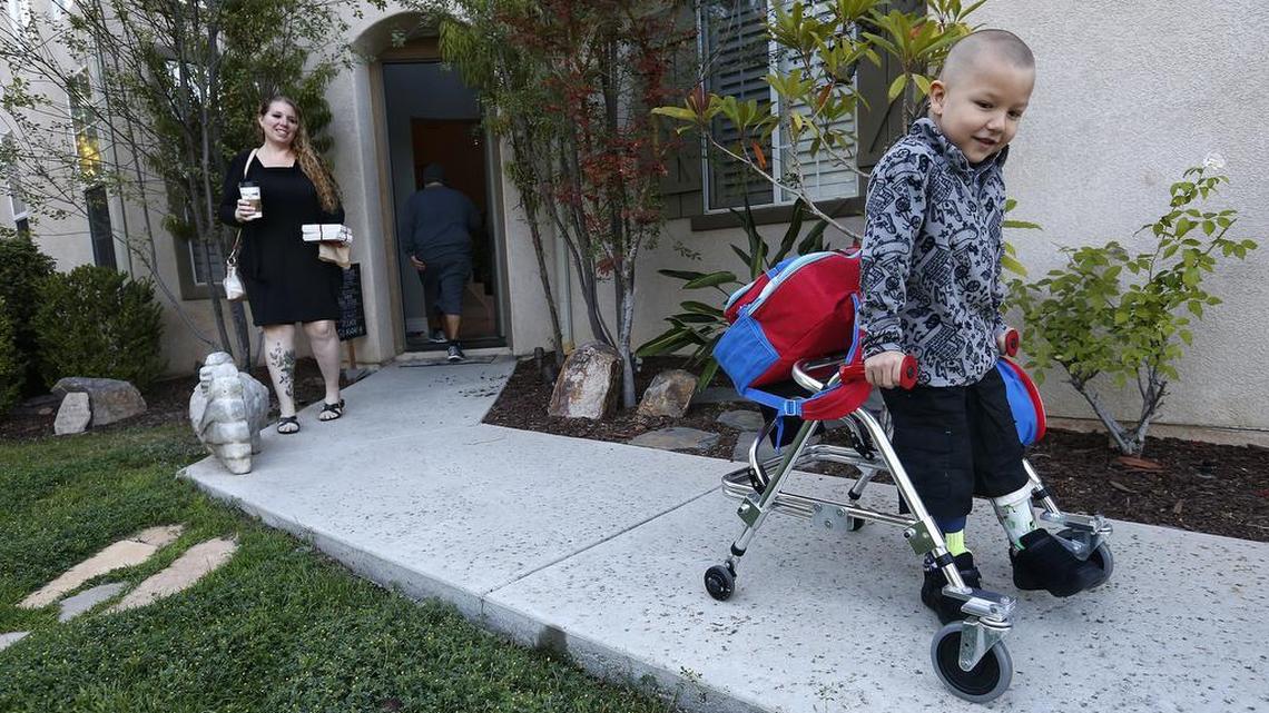 Erin Olivera watches her son Lucian walk to the family car on their way to Peach Hill Academy Elementary School in Moorpark, Calif., for the first day of school.