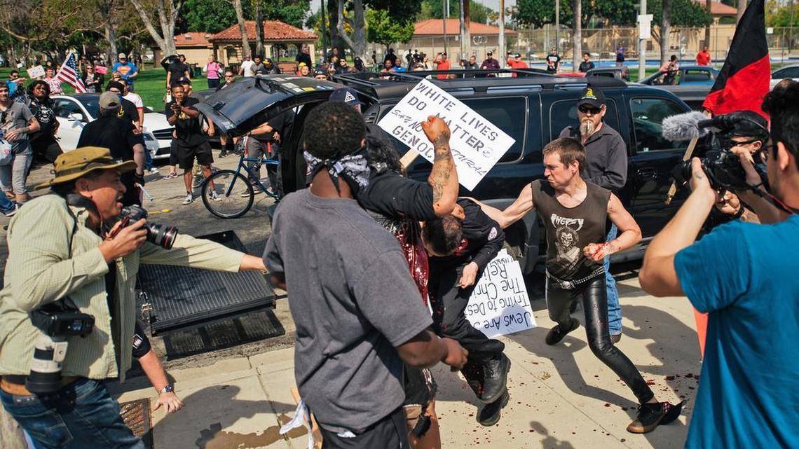 This photo provided by OC Weekly shows counter-protesters scuffling with a Ku Klux Klan member at an anti-immigration rally at Pearson Park in Anaheim on Saturday, Feb. 27, 2016. Three people were stabbed Saturday, one critically, after a small group of Ku Klux Klan members staging an anti-immigrant rally clashed with a larger gathering of counter-protesters, police said.