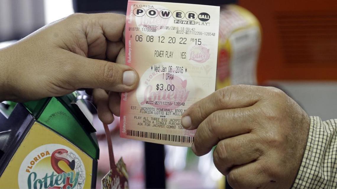 A clerk hands over a Powerball ticket to a customer Wednesday at a grocery store in Hialeah.