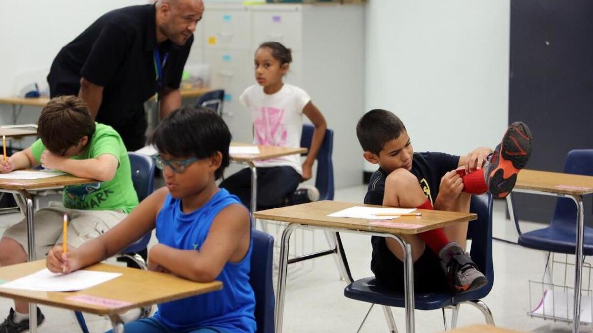 Teacher Herbert McArthur, Jr. works with Samantha N. as Jesus G. gets a little distracted from his studies during a summer program for children with ADHD run by Florida International University. FIU’s Center for Children and Families has been working with Miami-Dade County Public Schools to come up with the best ways to accommodate students with ADHD in the classroom. The camp asked that only the first names and last name initial of the children in the camp be used to help protect the children's privacy.