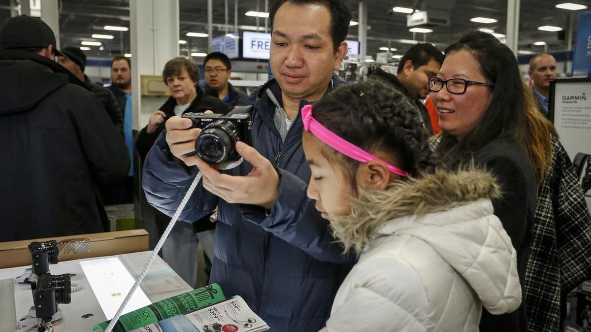 Koko Htwe looks at a camera at Best Buy with Sandy Htwe, center, and Nyo Nyo Soe on Thursday, Nov. 26, 2015, in Minnetonka, Minn.