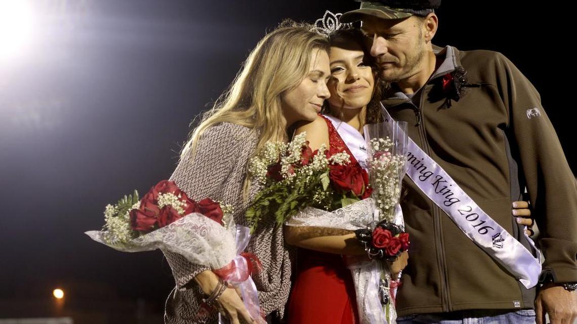 Kamiakin High School’s Unique Zier, center, stands with Aric, right, and Gina Ellison, the parents of her boyfriend, Cooper Ellison, after they were crowned homecoming queen and king during the school’s homecoming game against Walla Walla at Neil F. Lampson Stadium in Kennewick. Cooper died last weekend in an ATV accident while hunting.