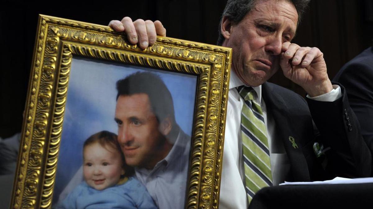 
 Neil Heslin, the father of Jesse, a 6-year-old boy who was killed in the Sandy Hook massacre in Newtown, Conn., holds a picture of them together as he wipes his eye while testifying on Capitol Hill in February 2013 before the Senate Judiciary Committee on the Assault Weapons Ban of 2013. The bill was defeated in the Senate. 
