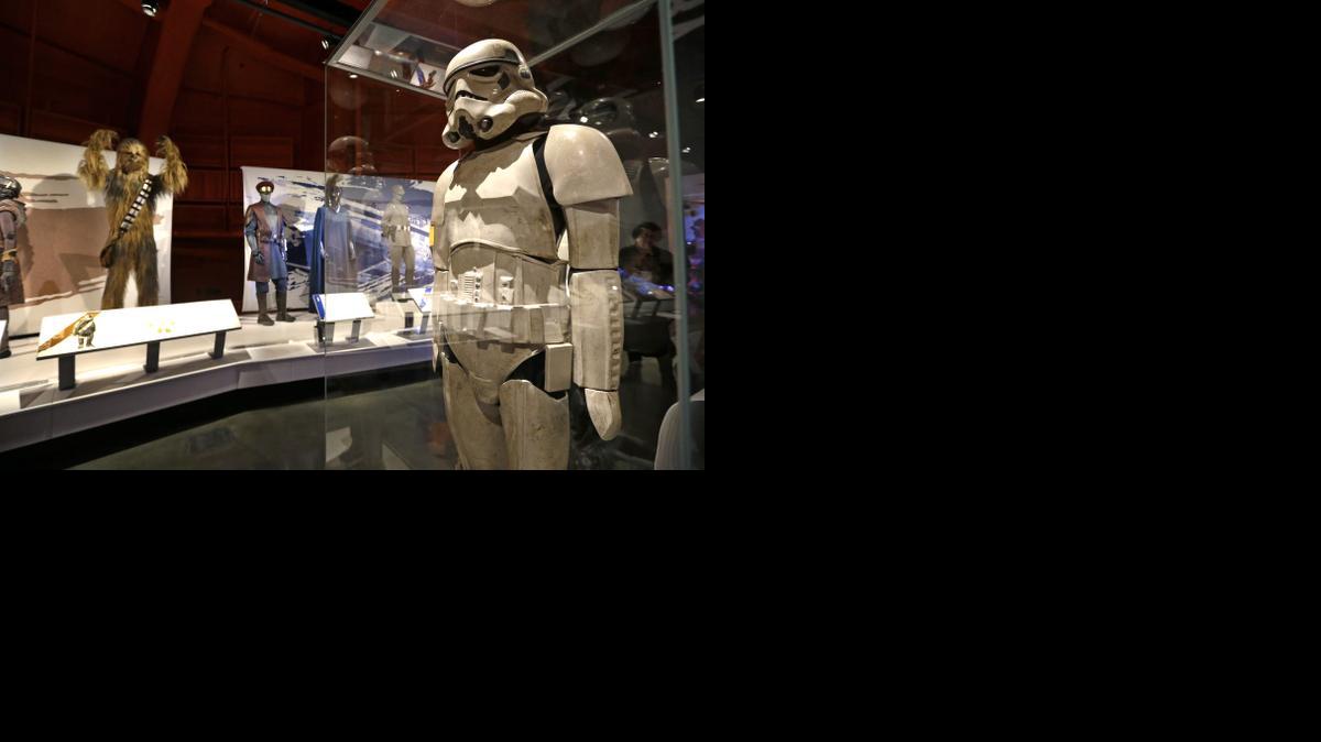 
In this photo taken Thursday,, a stormtrooper costume is displayed in view of Chewbacca and military uniforms as part of an exhibit on the costumes of Star Wars at Seattle’s EMP Museum. 
