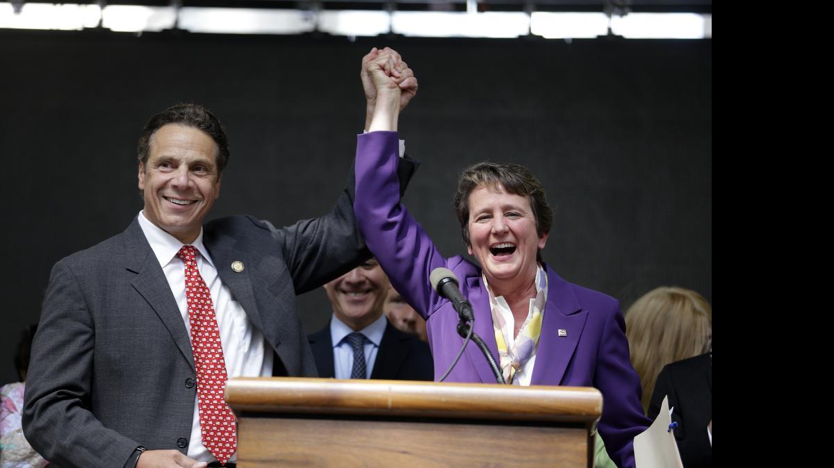 
New York Gov. Andrew Cuomo, left, and Mary Kay Henry, international president of the Service Employees International Union, celebrate their victory during a Wednesday, July 22, 2015, rally after the New York Wage Board endorsed a proposal to set a $15 minimum wage for workers at fast-food restaurants with 30 or more locations in New York. The increase would be phased in over three years in New York City and over six years elsewhere. 
