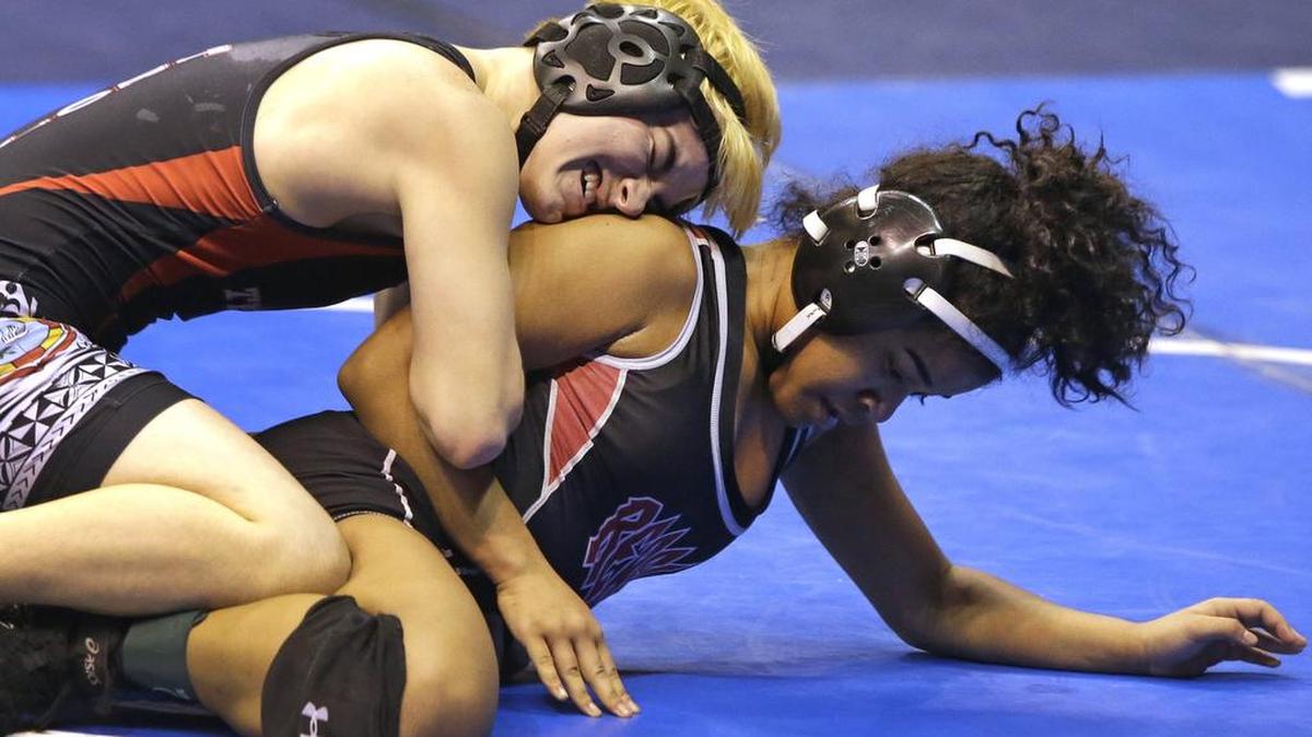 Trinity’s Mack Beggs, top, wrestles against Mya Engert of Amarillo Tascosa during the state wrestling tournament Friday in Cypress. Beggs, a transgender athlete, advanced to Saturday’s semifinals.