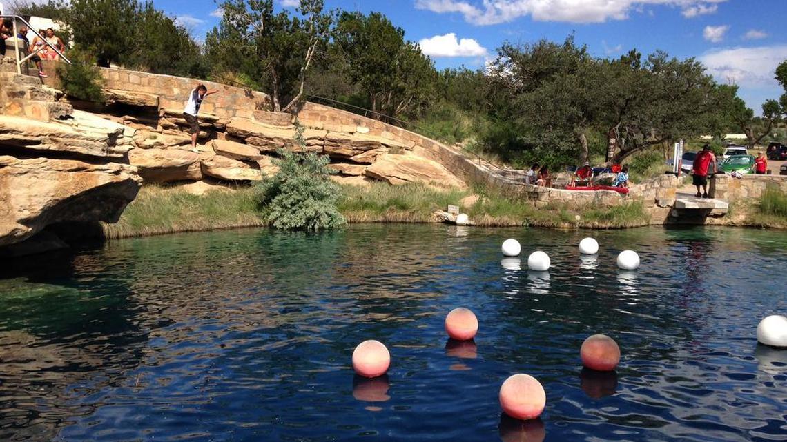 A boy leaps into the water at Blue Hole State Park in Santa Rosa, N.M. in June. A veteran San Diego scuba diving instructor died at the park over the weekend while exploring underwater caves that had been sealed for 40 years.