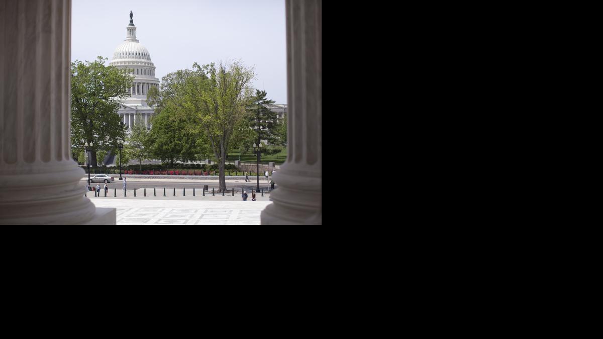 
The Capitol building is seen through the columns on the steps of the Supreme Court in Washington.
