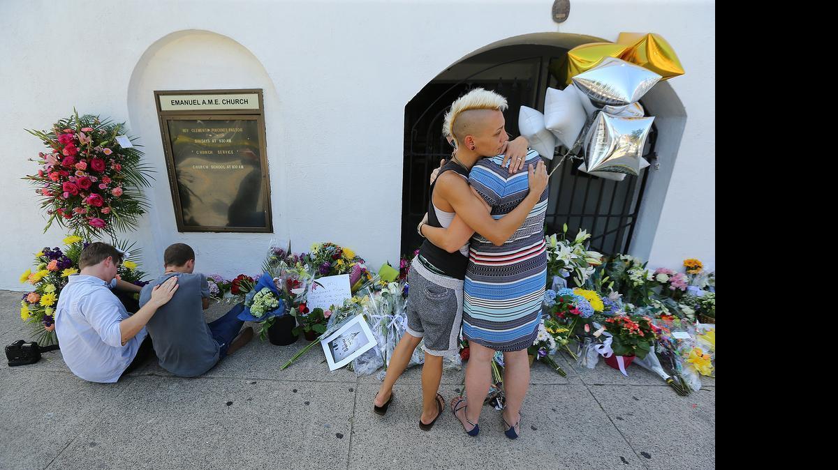 
From left, Alston Rich, Brad Hutchinson, Ashley Edge and Elizabeth Elliott comfort each other Thursday at the memorial in front of the Emanuel AME Church where nine people were killed including the pastor on Wednesday in Charleston, S.C.
