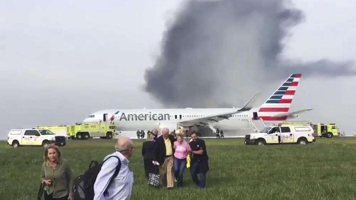 In this photo provided by passenger Jose Castillo, fellow passengers walk away from a burning American Airlines jet that aborted takeoff and caught fire on the runway at Chicago's O'Hare International Airport on Friday. Pilots on Flight 383 bound for Miami reported an engine-related mechanical issue, according to an airline spokeswoman.