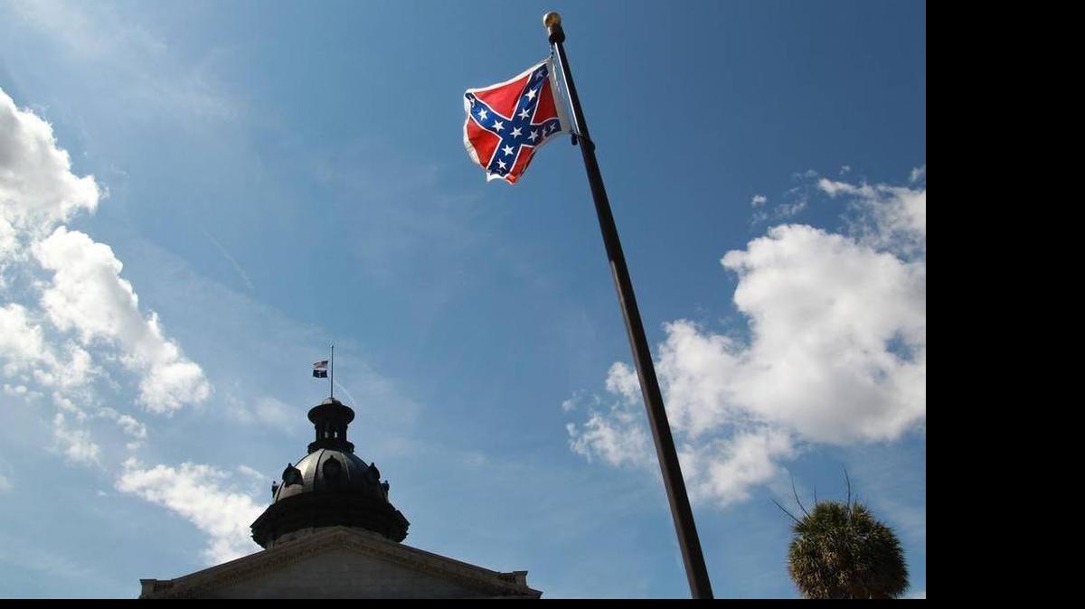 
The Confederate flag flies in front of the S.C. State House, next to a monument to Confederate soldiers. Atop the State House dome, the U.S. and state flags fly at half mast to honor nine people killed in what was apparently the racially motivated killings of nine people at the Emanuel AME Church in downtown Charleston.
