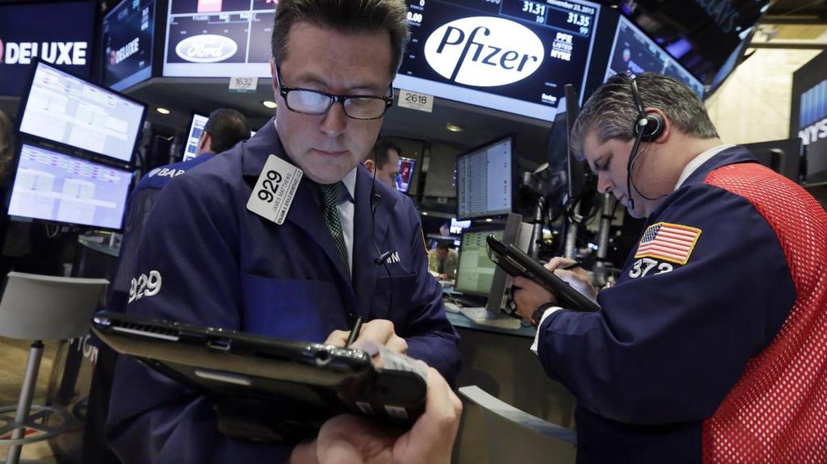 Traders James Matthews, left, and John Panin work at the post that handles Pfizer, on the floor of the New York Stock Exchange on Monday. Pfizer’s stock closed down 2.7 percent at $31.32, and Allergan’s stock fell 3.4 percent to $301.72.