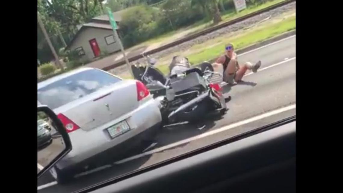 In a video posted to YouTube, the silver car is seen running over the motorcycle.