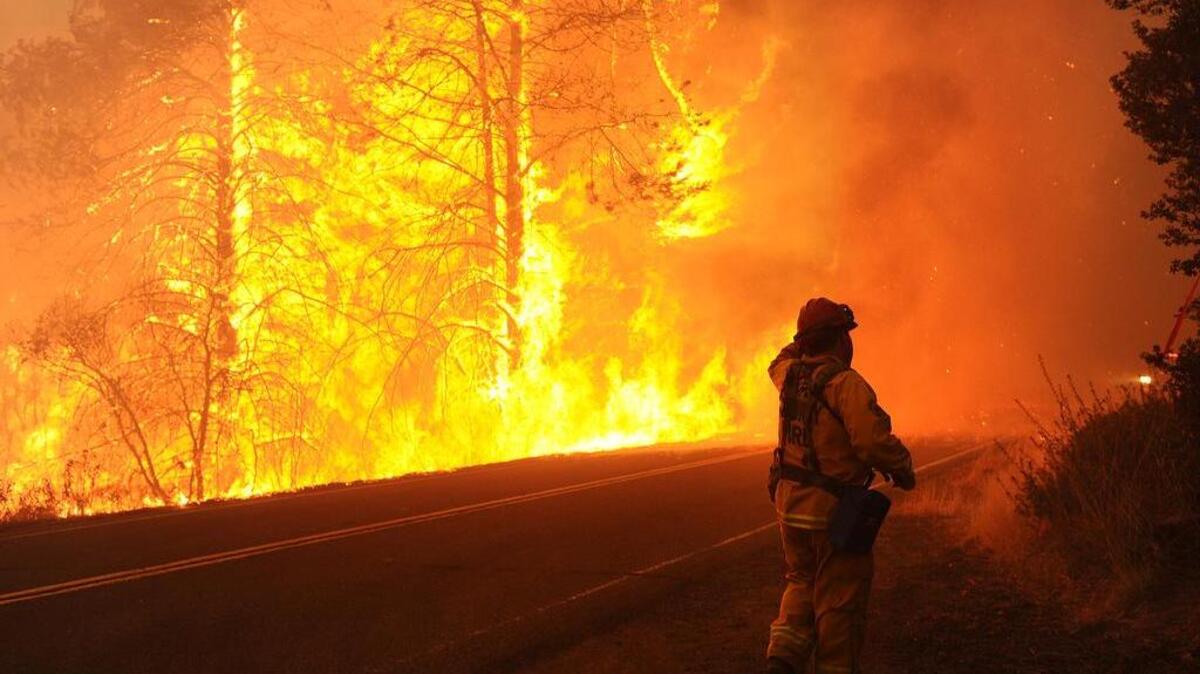 A firefighter runs to his fire truck southeast of Middletown, Calif., in September as winds kick up flames.