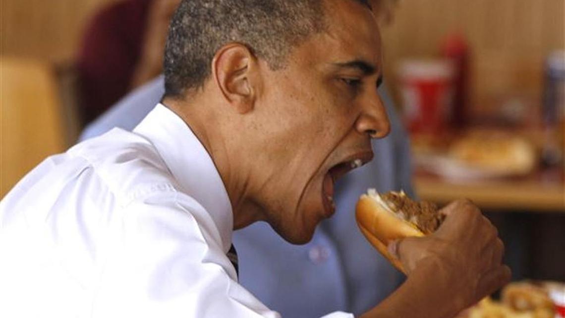 President Barack Obama takes a bite out of a chili dog during an unannounced visit to Rudy's Hot Dog in Toledo.