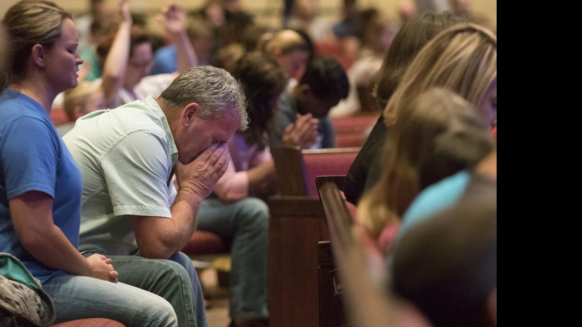 
Corey Groce puts his face in his hands as he prays during a prayer vigil at Redemption Point Church for the victims of shootings at a recruiting center and another U.S. military site a few miles apart in Chattanooga, Tenn., Thursday, July 16, 2015. Federal authorities said they were investigating the possibility it was an act of terrorism, and the FBI took charge of the case.

