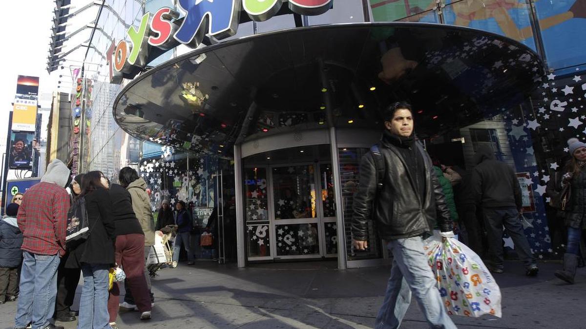 In this Dec. 24, 2011 photo, a last-minute shopper leaves the Toys R Us flagship store in New York's Times Square. A mall trade group said Wednesday, Dec. 28, 2011, that last minute shoppers gave merchants a solid lift during the final week before Christmas.