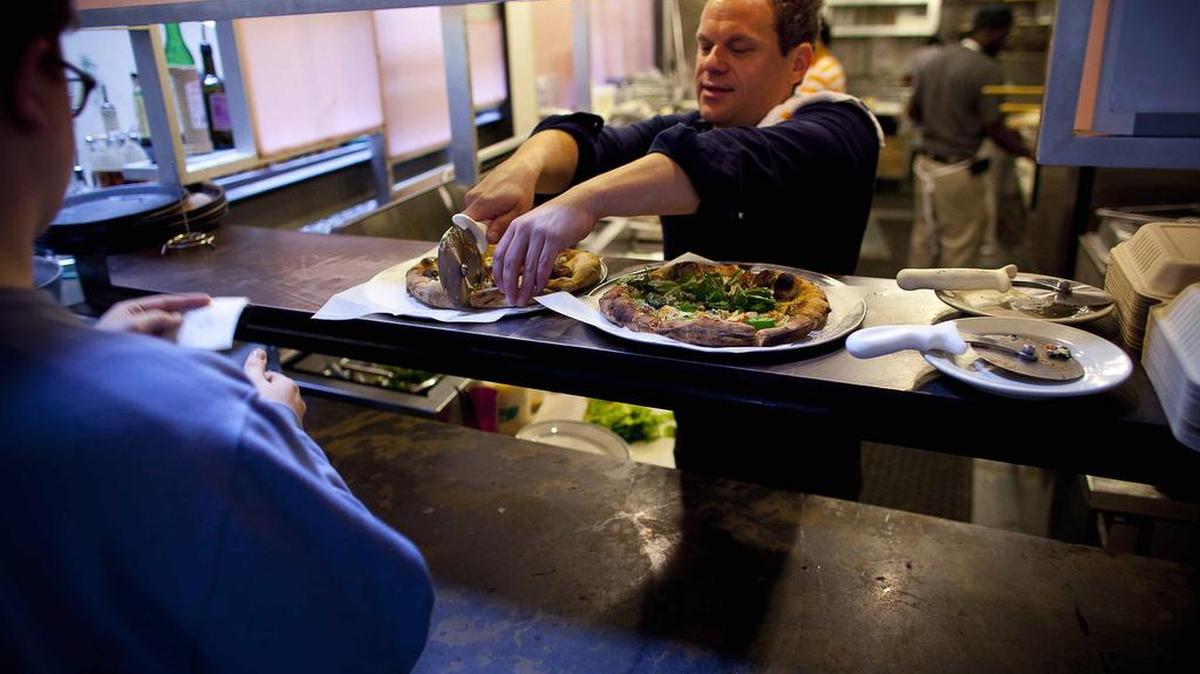 James Alefantis, the owner of the pizza place Comet Ping Pong, slices pizza at the restaurant in Washington, Nov. 19, 2016. Alefantis and his employees came under fire online as false allegations emerged claiming Hillary Clinton took part in a child trafficking ring at the restaurant, part of the fake news storm that took over social media during the election.