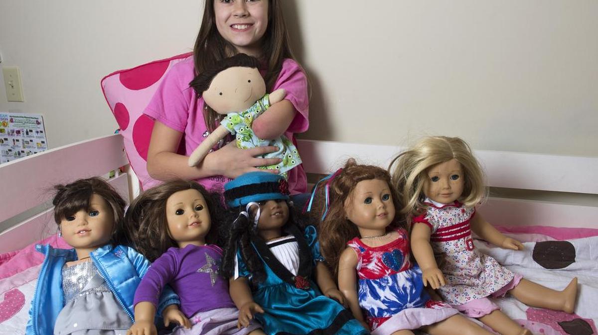 Jordan Reeves displays her American Girl dolls, while holding her favorite doll, which she calls Little Boo.