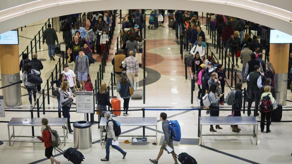 Travelers wait to go through a security checkpoint at Hartsfield–Jackson Atlanta International Airport ahead of the Thanksgiving holiday Wednesday, Nov. 25, 2015, in Atlanta.